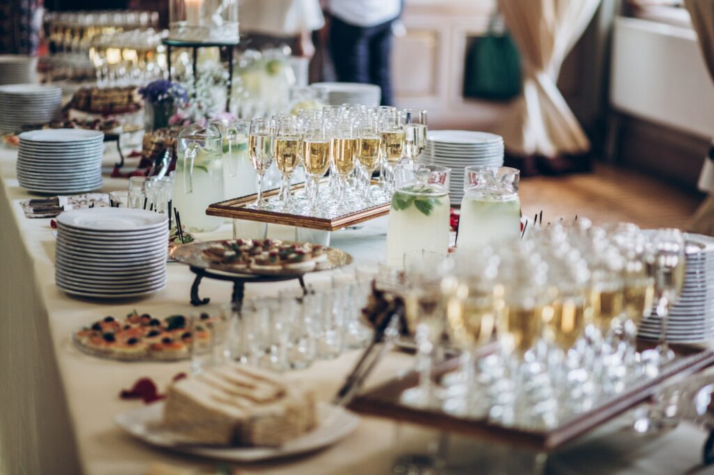 Stylish champagne glasses and food appetizers on table at wedding reception